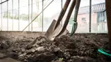 Een schep en ander tuingereedschap worden gebruikt op wat grond